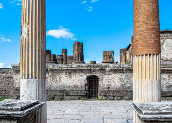 Ruïnes van Pompeii met stenen en bakstenen Romeinse zuilen onder blauwe lucht