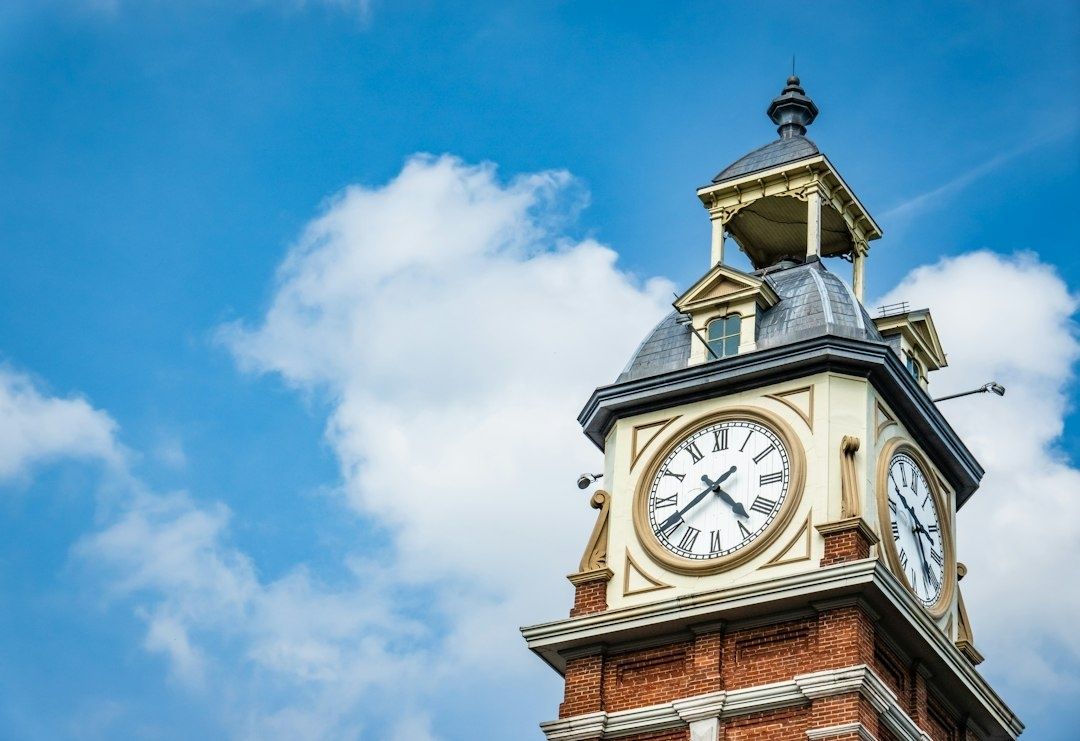 Historische klokkentoren met wijzerplaten tegen een blauwe lucht